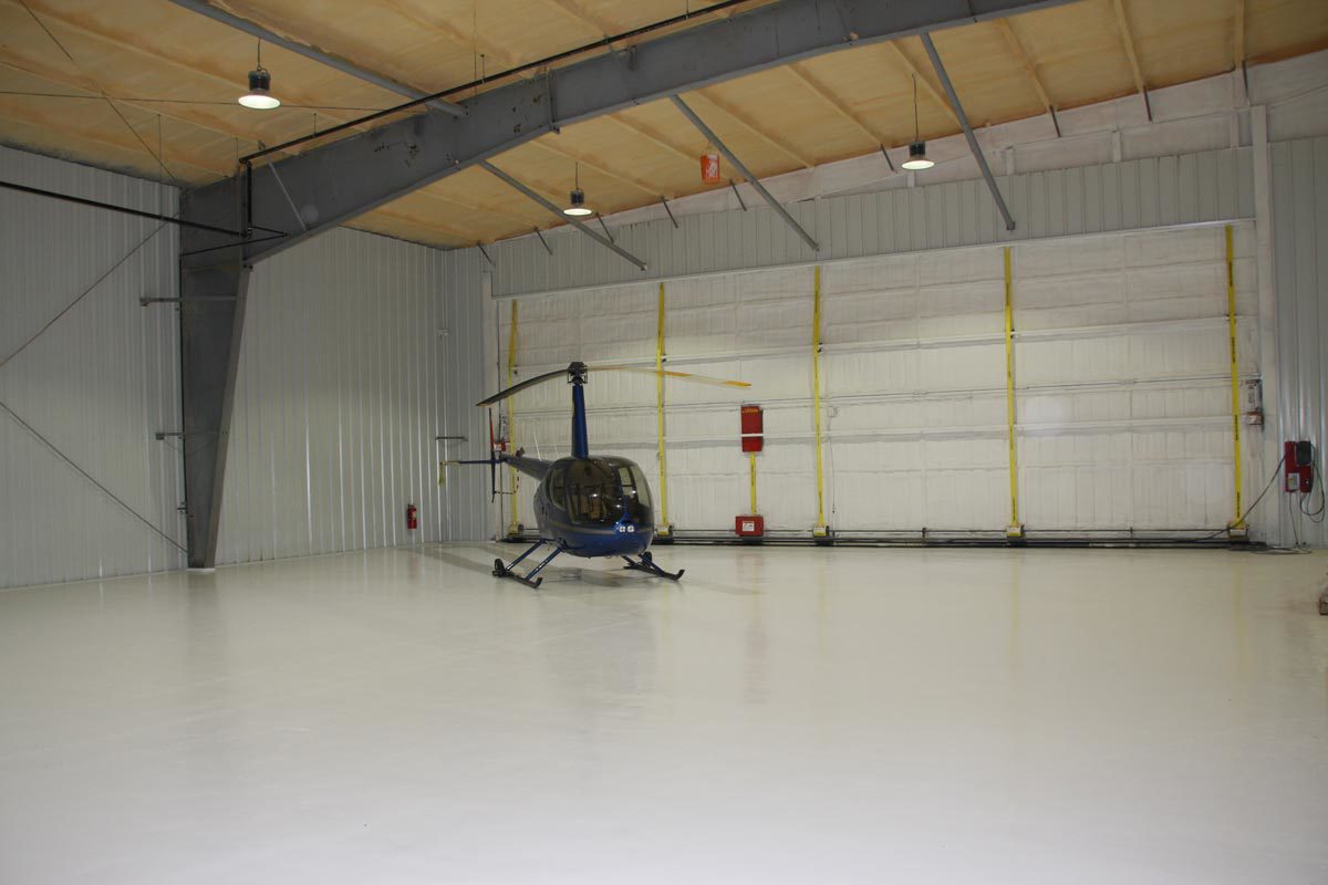 helicopter inside steel building with wide opening door