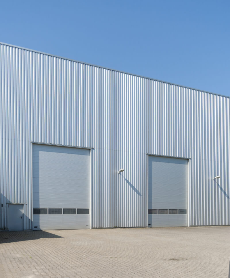 large metal building exterior with ribbed grey wall sheeting