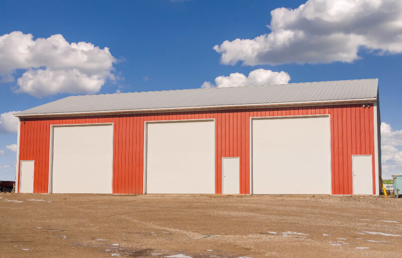 equipment storage Garage with 3 large overhead doors and 1 man door