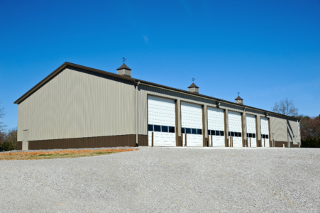 equipment storage building with high pitch and 6 large overhead doors with copulas
