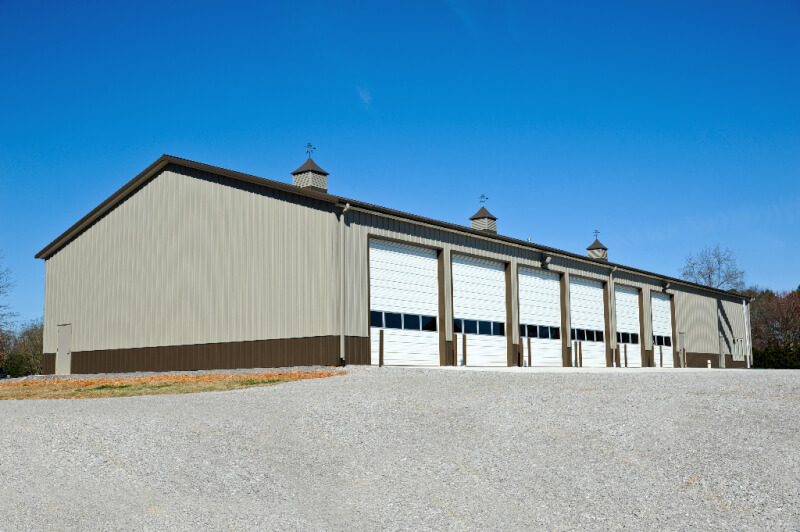 equipment storage building with high pitch and 6 large overhead doors with copulas