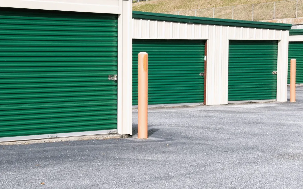 Steel mini-storage building with green roll-up doors