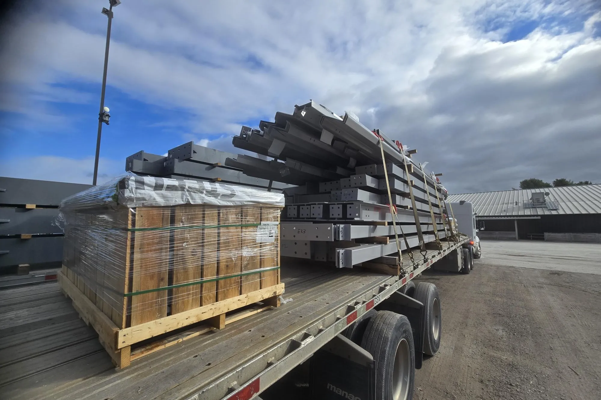 Bundled steel framing and panels on a delivery trailer